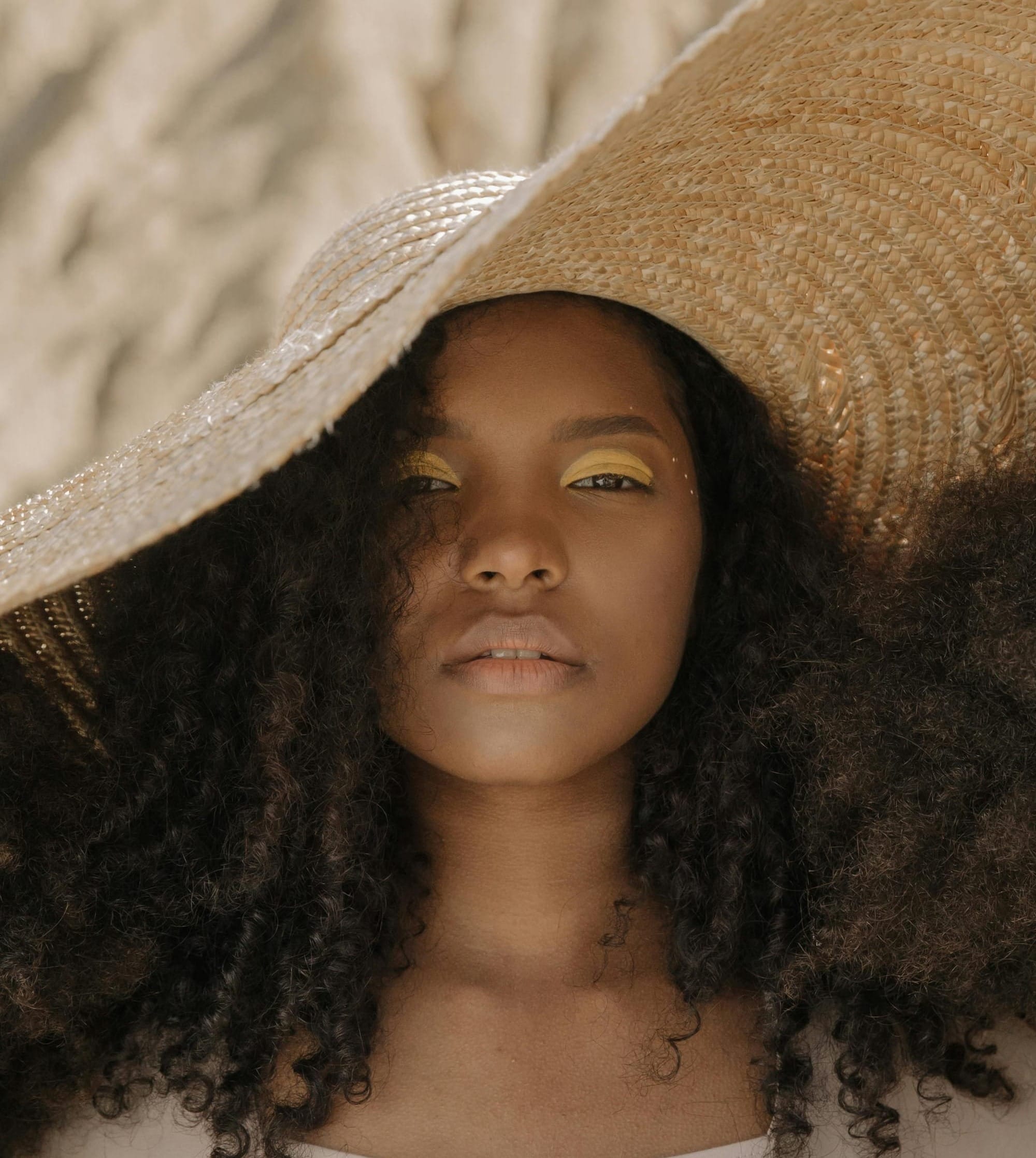 woman with curls and floppy hat