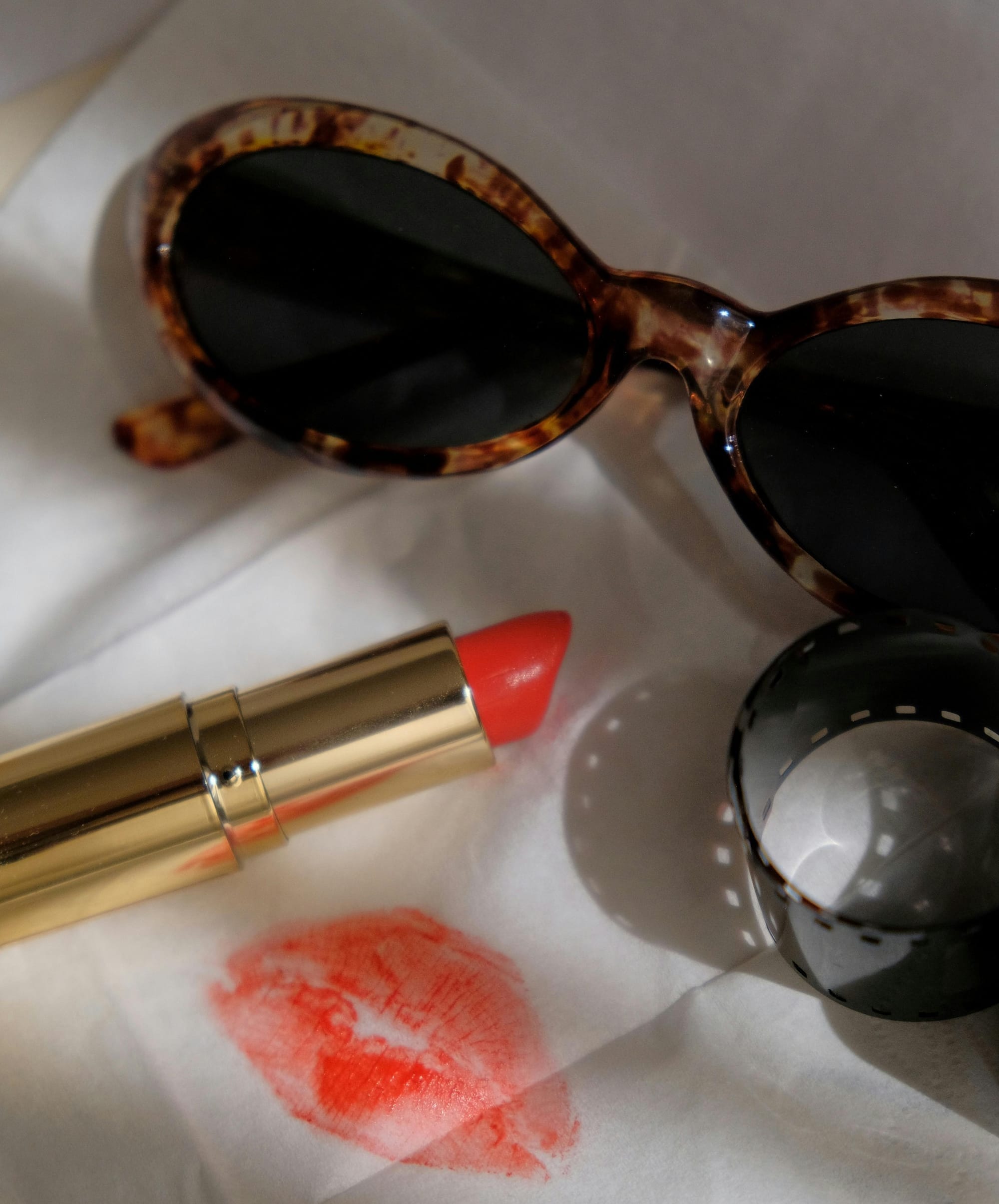 Close up on red Lipstick and retro sunglasses with soft light