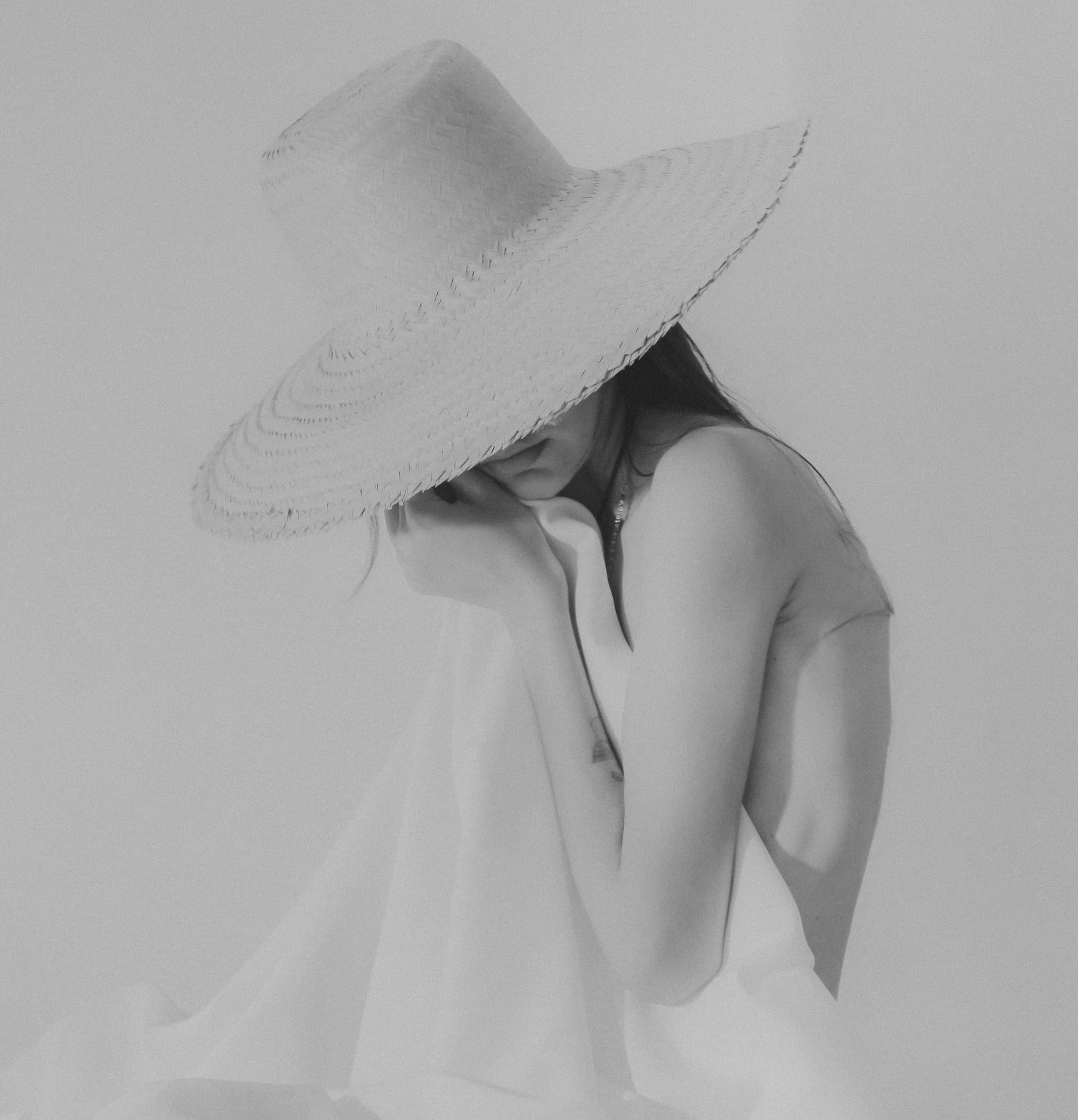 soft black and white portrait of a woman with sunhat