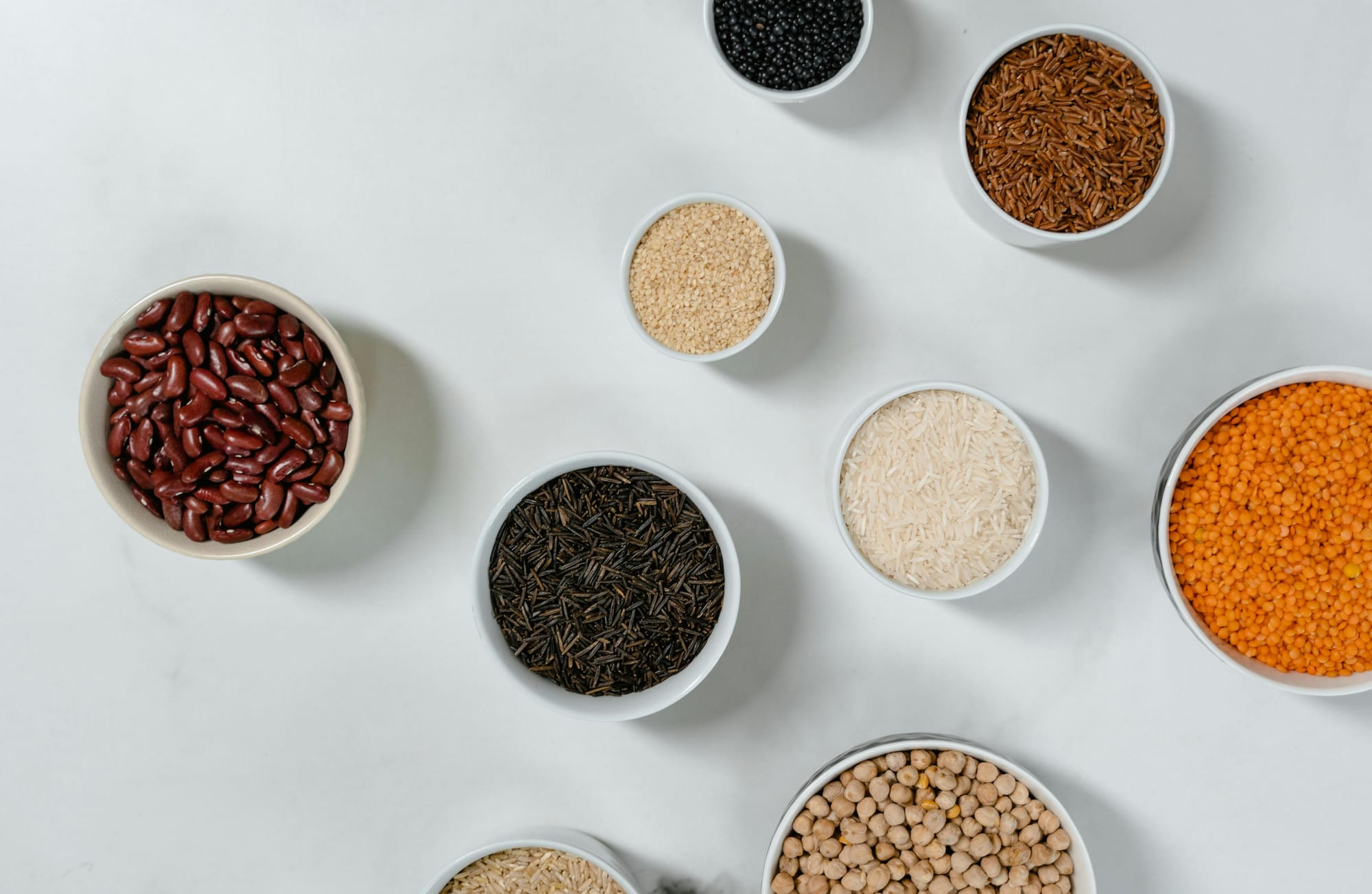 A minimalist display of grains and legumes like chickpeas, lentils, and farro—essential ingredients in the Mediterranean diet.