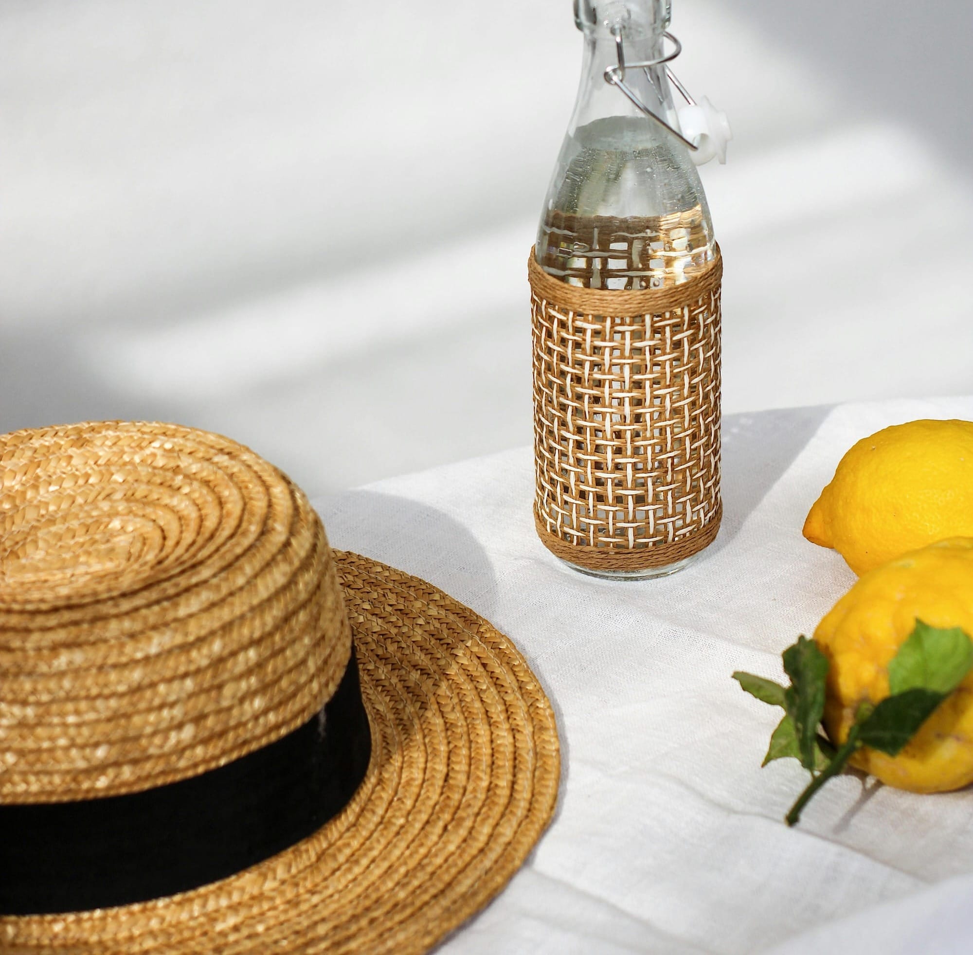 boater hat next to lemons and water