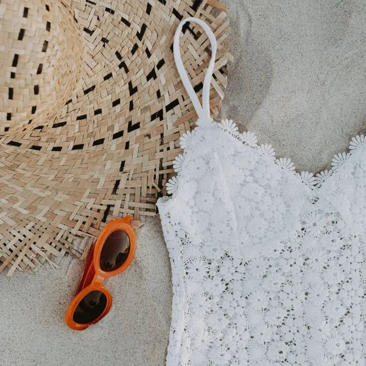 Beach close-up with retro sunglasses, knit swimsuit and straw hat